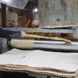Glue spreading and veneer lay-up process in plywood manufacturing.