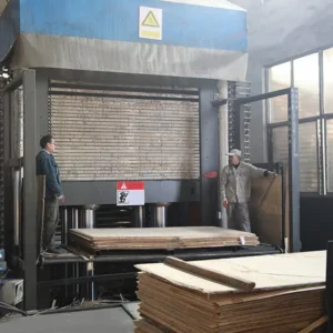 Hot pressing process in plywood manufacturing using high temperature and pressure.