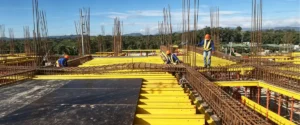 Travi in legno H20 e compensato rivestito con pellicola utilizzati insieme in un sistema di casseforme per calcestruzzo destinato a progetti edilizi.