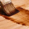Plywood being stained to create an even and attractive wood finish.
