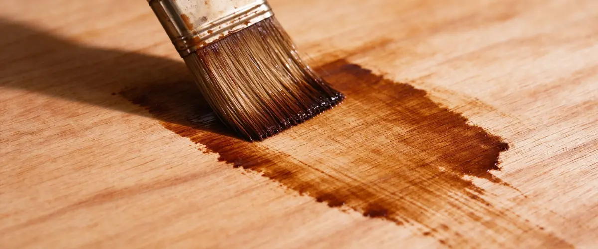 Plywood being stained to create an even and attractive wood finish.