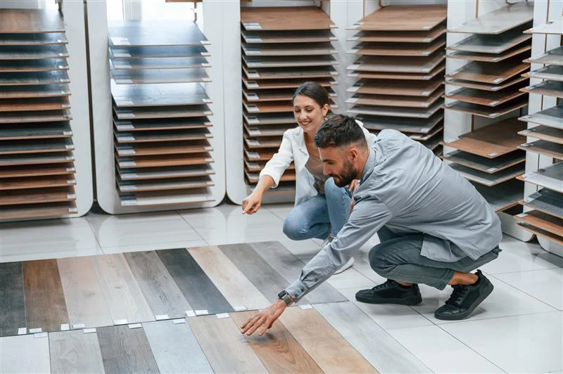 Couple choosing SPC wood-grain flooring in tile showroom